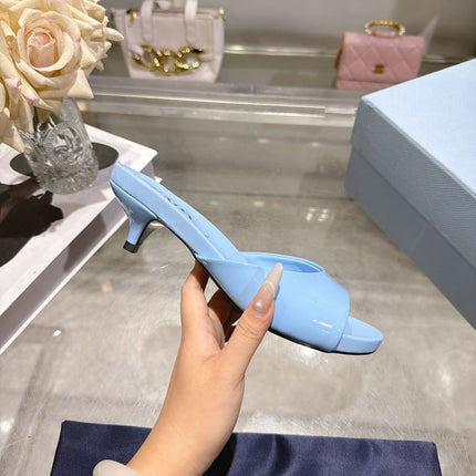 PRADA 26S LOGO EMBOSSED KITTEN HEEL MULES IN SKY BLUE PATENT CALFSKIN